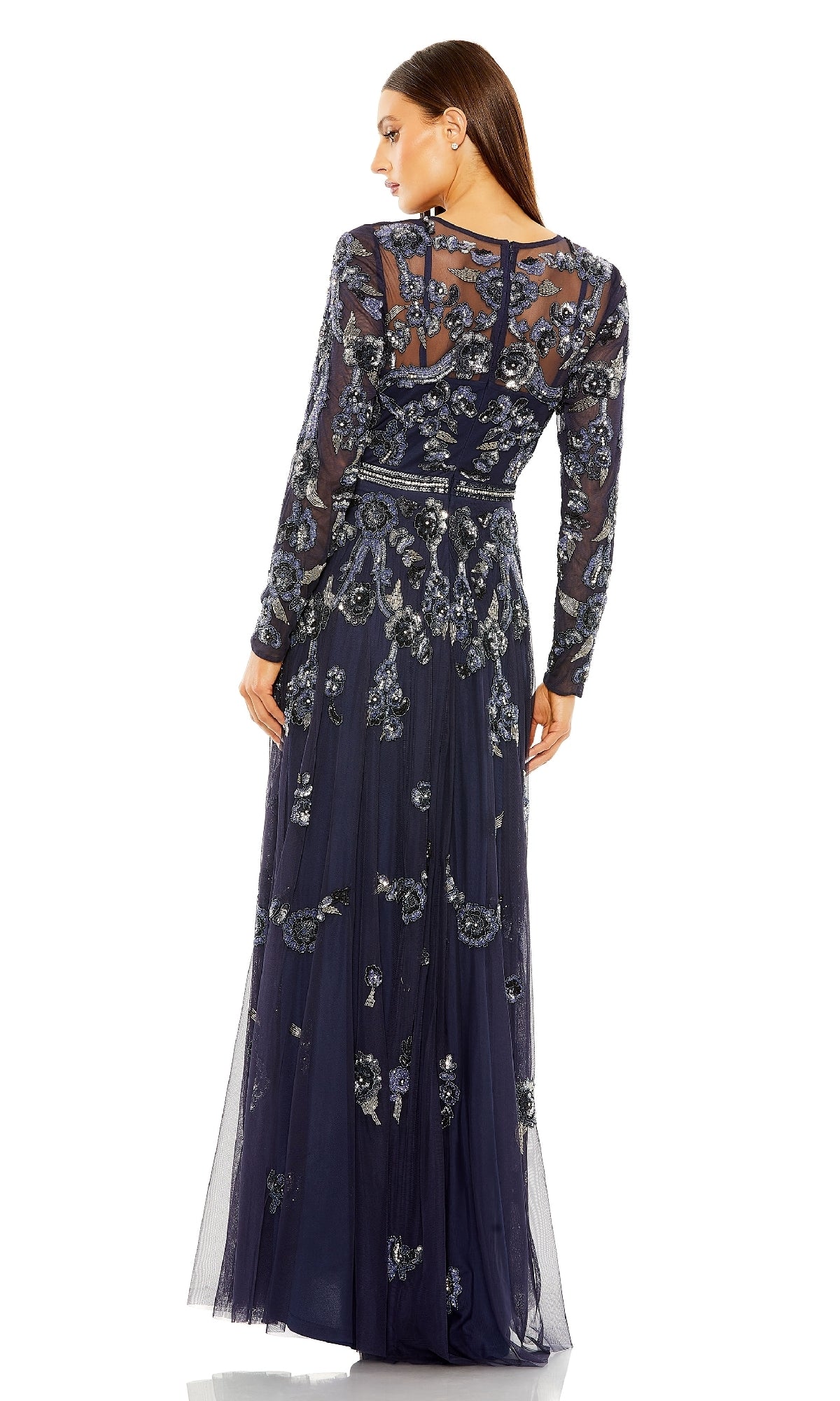 A woman is seen from the back wearing the Mac Duggal 10013 long sleeve blue formal dress, featuring floor-length design, detailed silver floral embroidery, and delicate beading.